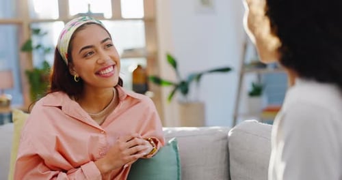 Two Women Talking and Smiling on a Couch