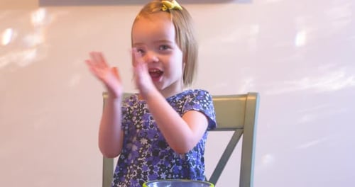 Little Girl Clapping Hands at the Table