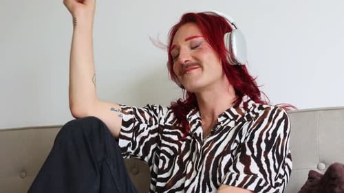 Young non-binary person listening to music with headphones