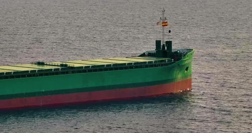 Aerial Top Down View of a Bow From a Large Cargo Ship Traveling with Speed Over Blue Ocean