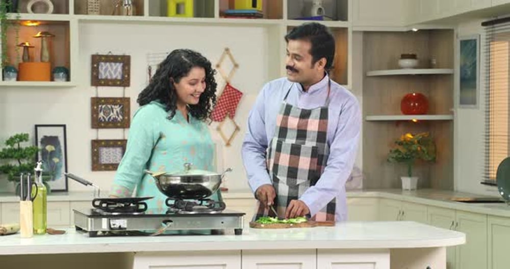 Belle femme regarde comment son mari prépare le dîner dans la cuisine ...