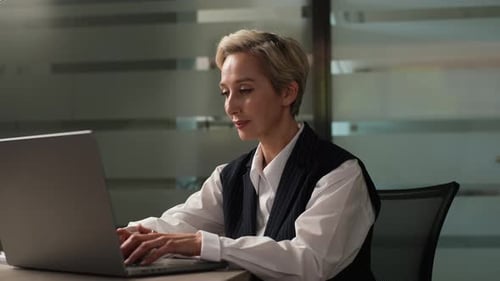 Woman Works On Laptop in Modern Office