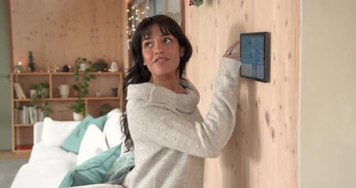 Woman Interacts with Smart Home Device on Wall