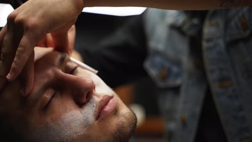 Barber Shaves Man's Eyebrows With a Straight Razor