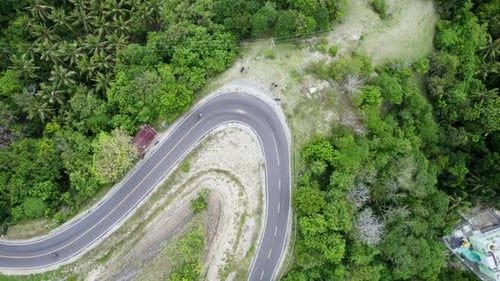 Drone View of a Curved Winding Road Through Dense Tropical Jungle Forest