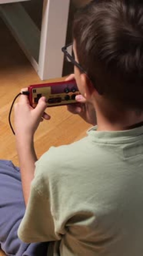 Child playing handheld video game console at home