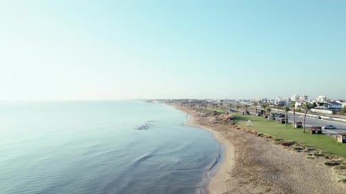 Early Morning Footage of a Public Beach Drone Rises Up Above the Sea Surface Aerial View