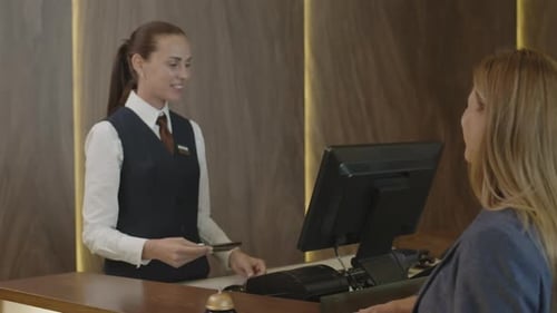 Woman Giving Passport to Receptionist at Hotel Check-In