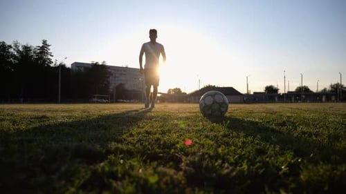 Silhouette of Sportsman Shooting a Penalty Kicks on Stadium at Sunset Professional Footballer