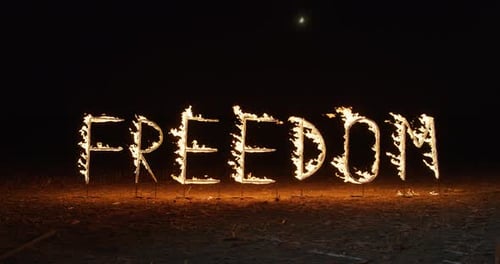 Cinematic shot of the Word FREEDOM Made of Bright, Glowing, Sparkling Pyrotechnic Fir