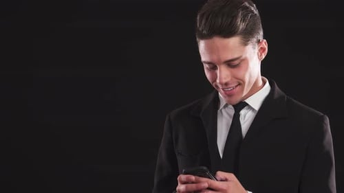 Smiling Man Typing on Mobile Phone in Suit