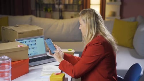 Woman Working at Desk Using Smartphone and Laptop