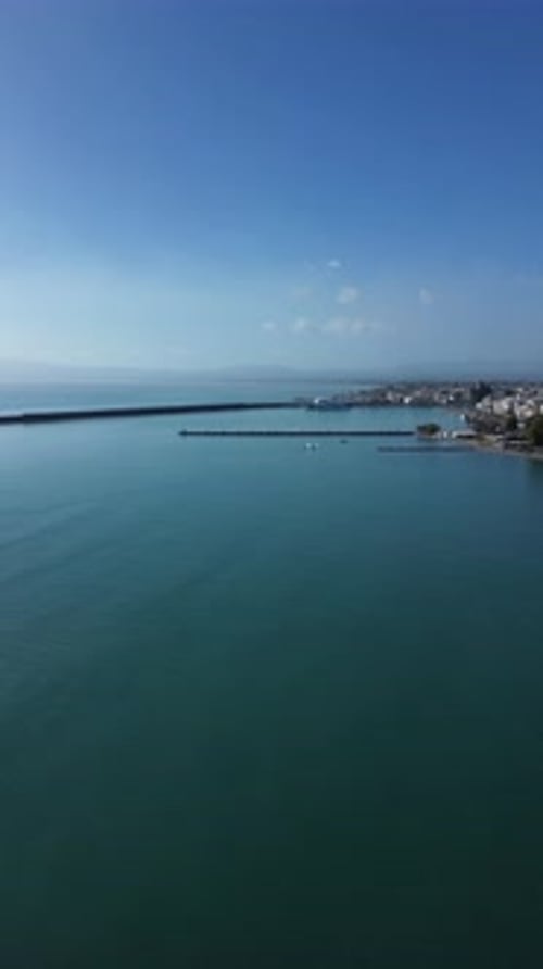 Aerial , push in, right pan vertical footage, showcasing Kalamata's port and cityscape on a clear