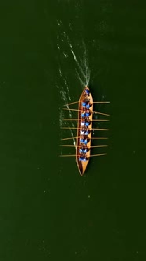 Vue aérienne d'une équipe faisant de l'aviron à bord d'un chaloupe en bois historique, en Finlande