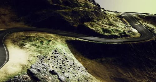 Winding Road Through Rocky Terrain Under a Dramatic Sky at Dusk