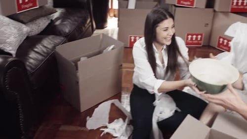Young Couple Unpacking Boxes on Floor