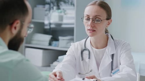 Female Doctor Giving Medical Consent Form to Patient for Signing in Clinic