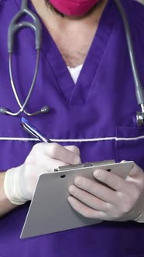 Health Care Worker Writing on Clipboard Close Up
