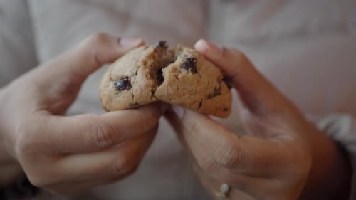 Hands Break Chocolate Chip Cookie With Melted Chocolate