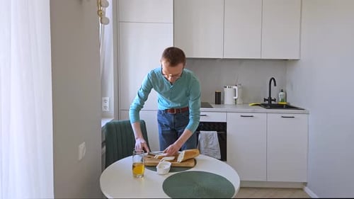Homme étalant du fromage à la crème sur un sandwich