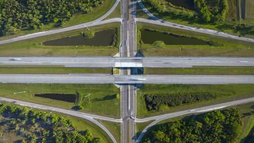 View From Above of Busy American Highway Bridge with Fast Moving Traffic in Green Florida Area
