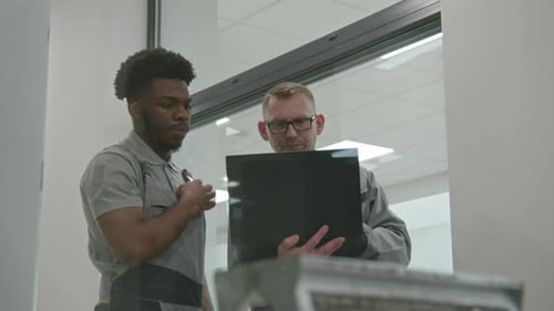 Construction Team Discussing Plans on Tablet Indoors