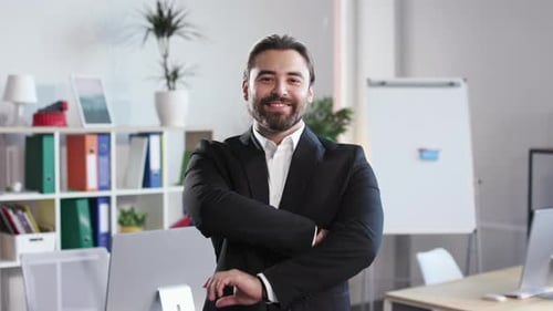 Portrait of Smiling Man Posing at Office with Crossed Arms