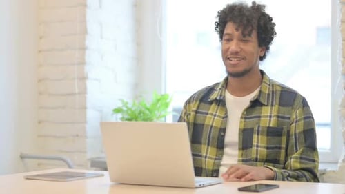 Online Video Chat on Laptop by African Man in Office