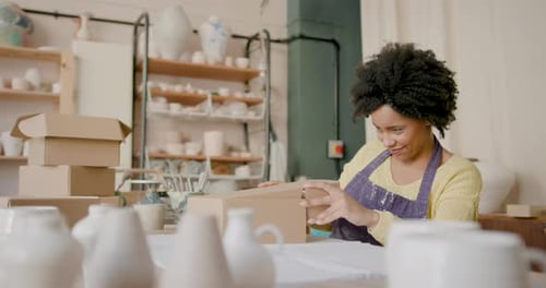 Potter Packaging Finished Ceramic Pieces in Studio