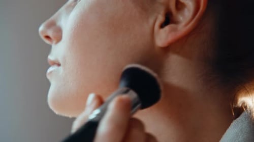 Woman Applying Makeup with Brush Close Up