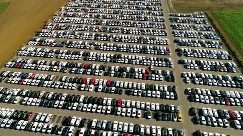 Aerial footage of finished cars ready to be shipped on huge distribution center