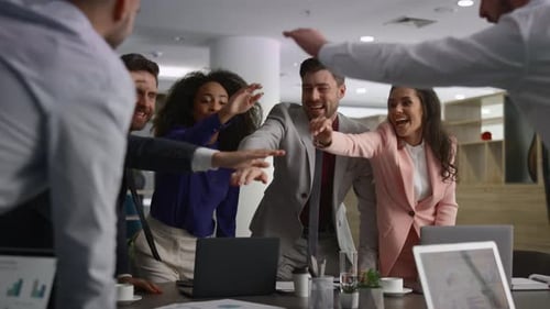 Multiracial business team celebrating corporate success in a modern financial office