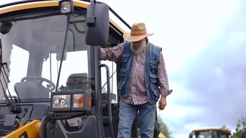 Senior Man Climbing into the Tractor Cab