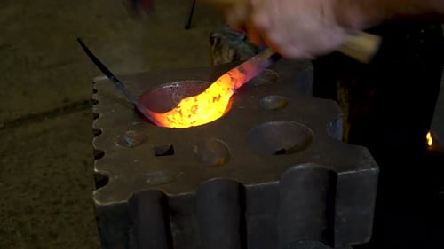 Blacksmith Shaping Hot Metal on Anvil with Hammer