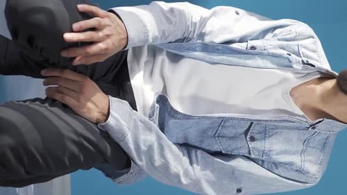 Young Man in Denim Jacket Posing on Blue