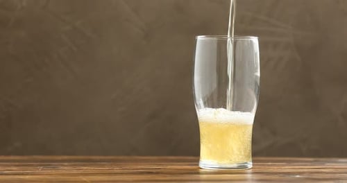 Golden Beer Pouring into a Clear Glass