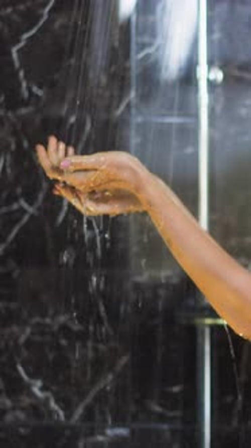 Water Flowing Over Hand in Shower