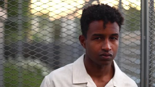 Young Adult Man Posing by a Fence