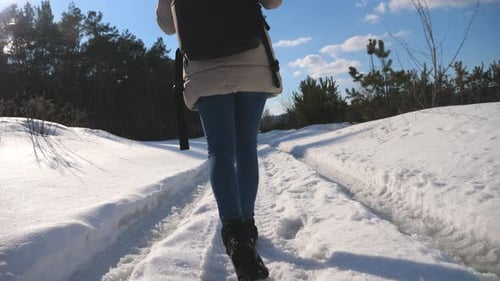 Feet of Female Tourist Walking on Snow Woman with Backpack Going at Forest Trail During Winter