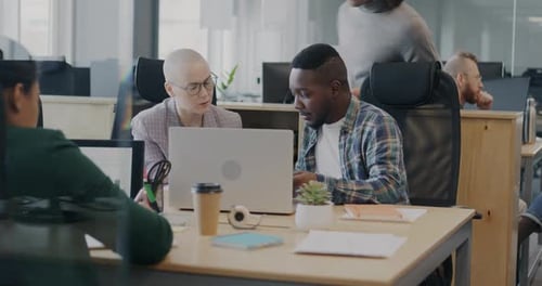 Diverse Team Collaborating on Laptop in Modern Office