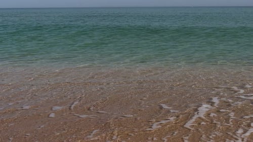 Gentle ocean waves on sandy shore