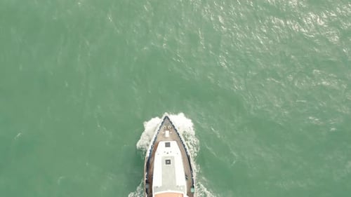 A drone shot of a lifeboat passing underneath.