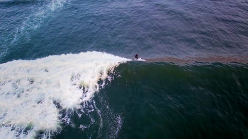 Aerial top down view of a man surfing a big wave