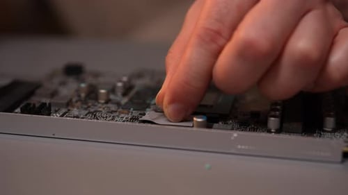 Hands Repairing Computer Circuit Board with Tweezers Close Up