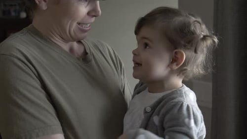 Soldier Holding Adorable Infant Indoors