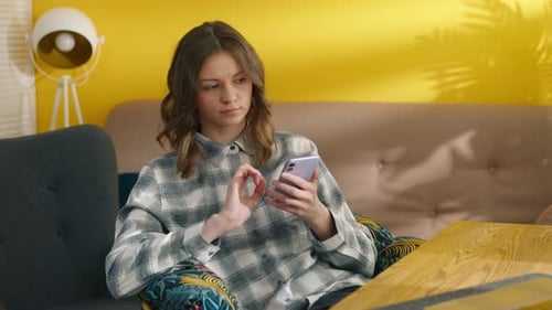 Woman Using Smartphone Sitting Indoors During Daytime