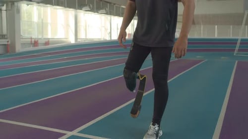 Determined Athlete with Prosthetic Leg on Running Track