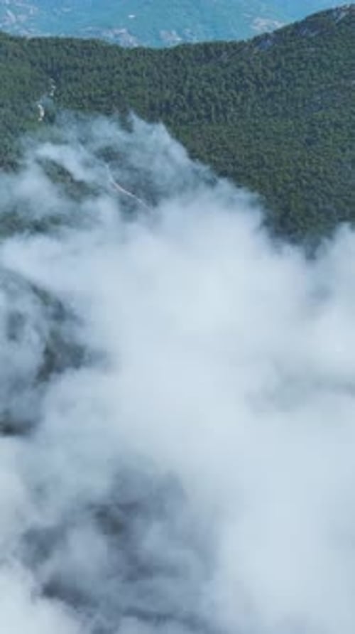 Vertical Video Peaceful Mountain Views With Green Forests Floating Clouds and Bright Blue Skies for