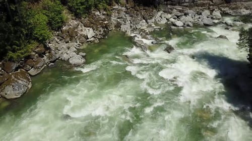 An einem strahlend sonnigen Frühlingstag fließt eine Flussströmung durch das Tal rund um die glatten Felsen