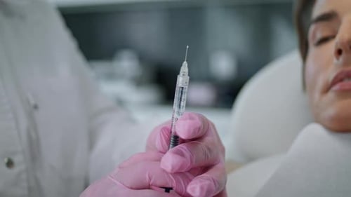 Hands Holding Syringe Collagen Before Injecting in Woman Client Face Close Up